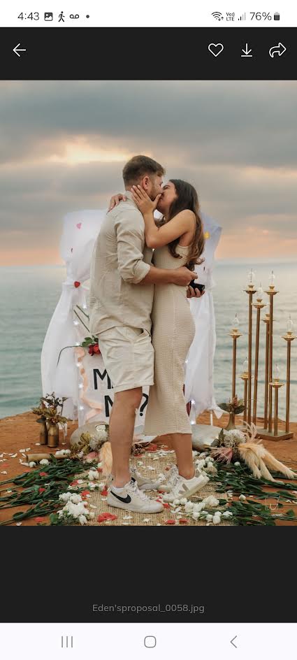 A newly engaged couple embracing beside their seaside proposal setting