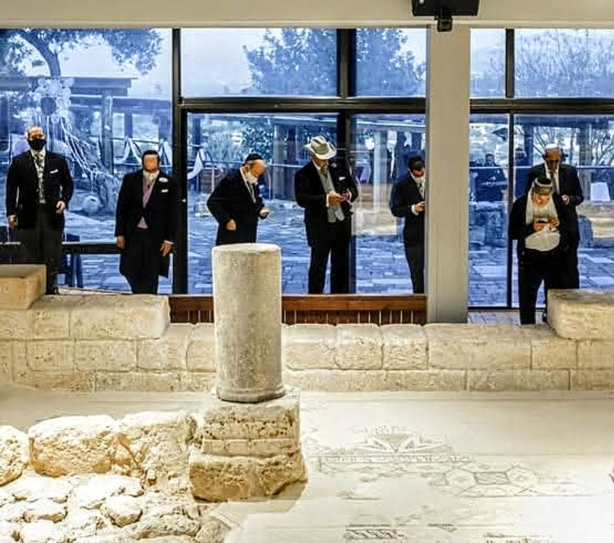 Guests visiting a historic synagogue with ancient stonework and mosaics