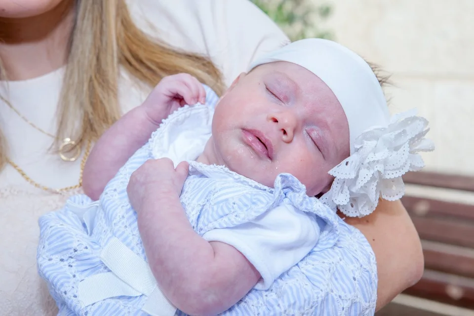 A newborn resting in a parent’s arms